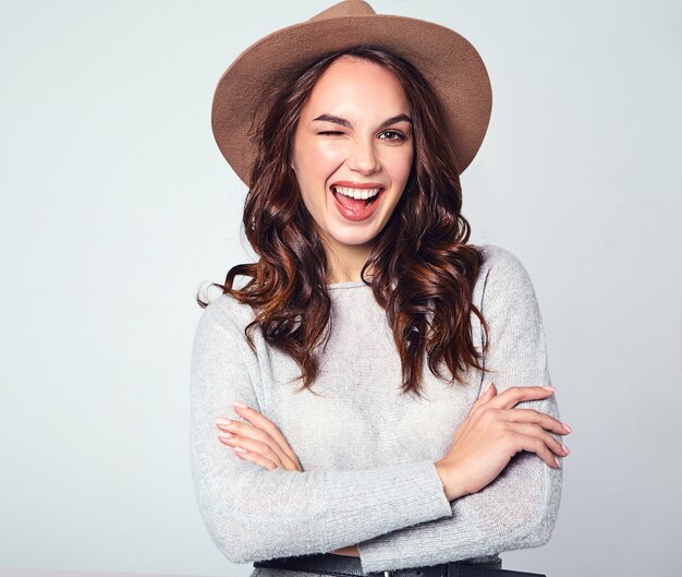 Portrait of young stylish laughing model in gray casual summer clothes in brown hat with natural makeup