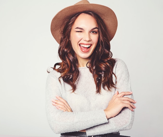 Portrait of young stylish laughing model in gray casual summer clothes in brown hat with natural makeup