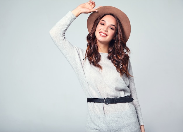 Portrait of young stylish laughing model in gray casual summer clothes in brown hat with natural makeup