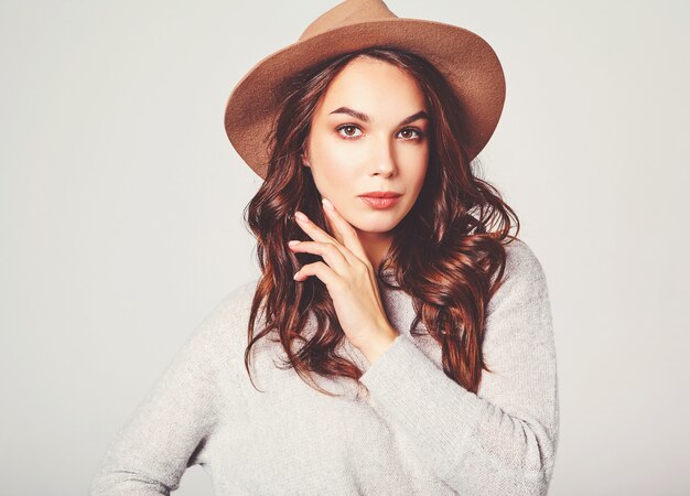 Portrait of young stylish laughing model in gray casual summer clothes in brown hat with natural makeup