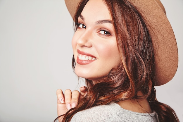 Foto gratuita ritratto di giovane elegante modello ridendo in abiti estivi casual grigi in cappello marrone con trucco naturale