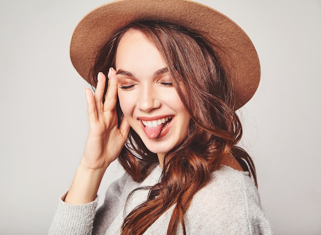 Portrait of young stylish laughing model in gray casual summer clothes in brown hat with natural makeup