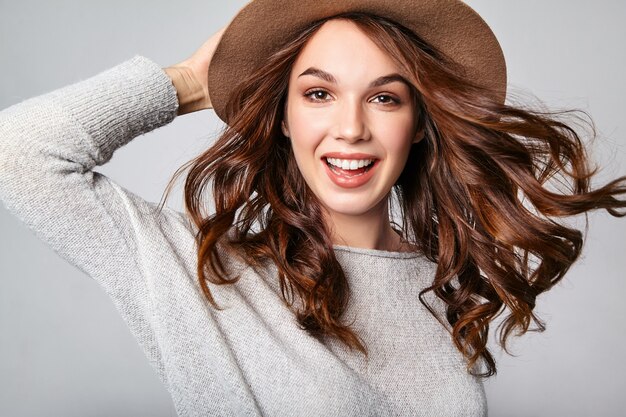 Portrait of young stylish laughing model in gray casual summer clothes in brown hat with natural makeup