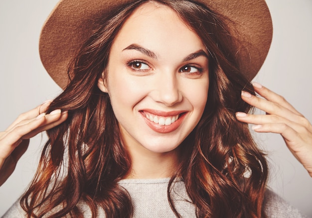 Portrait of young stylish laughing model in gray casual summer clothes in brown hat