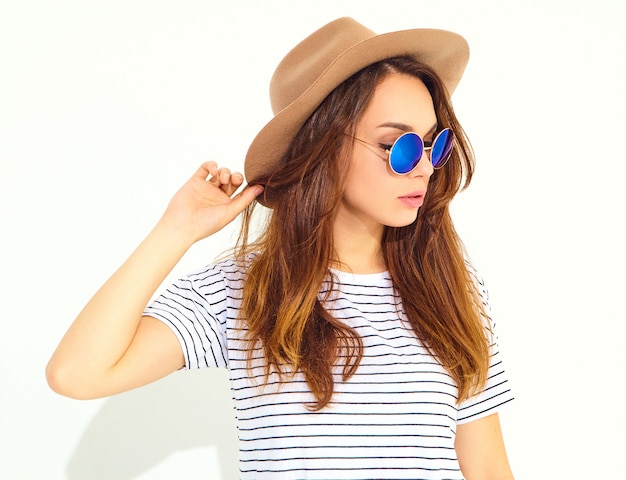 Portrait of young stylish laughing woman model in casual summer clothes in brown hat isolated on white wall