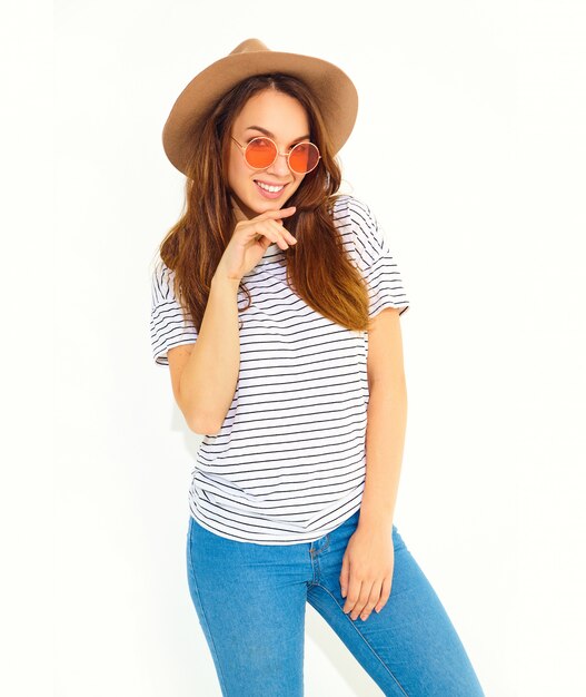 Portrait of young stylish laughing woman model in casual summer clothes in brown hat with natural makeup isolated on white wall.