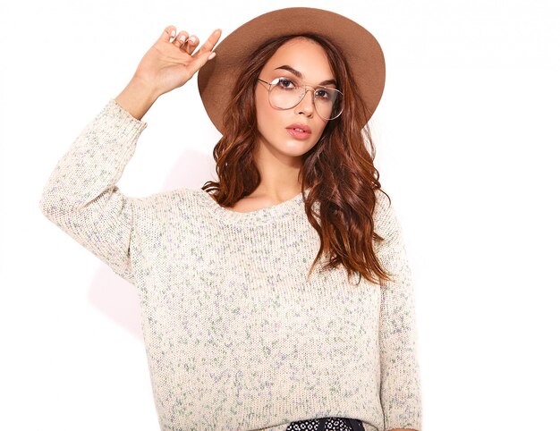 Portrait of young stylish model in casual summer clothes in brown hat with natural makeup in glasses on white