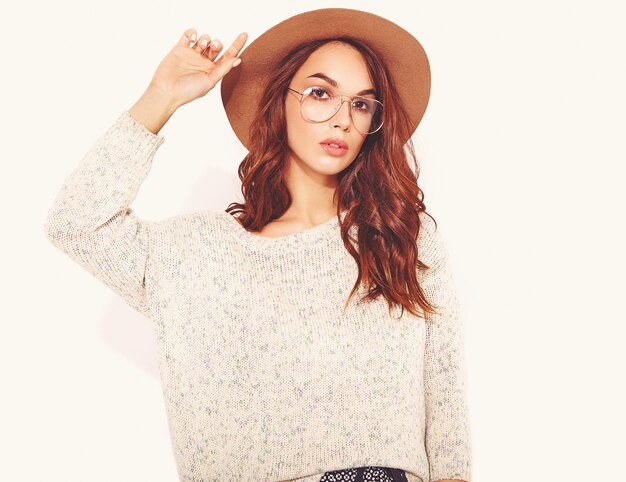 Portrait of young stylish model in casual summer clothes in brown hat with natural makeup in glasses on white