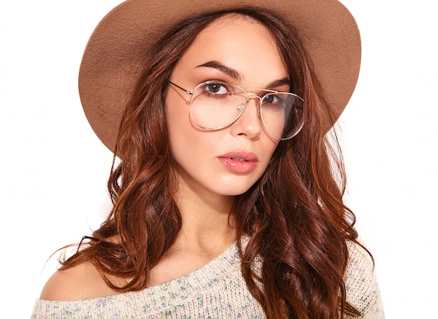 Portrait of young stylish model in casual summer clothes in brown hat with natural makeup in glasses on white