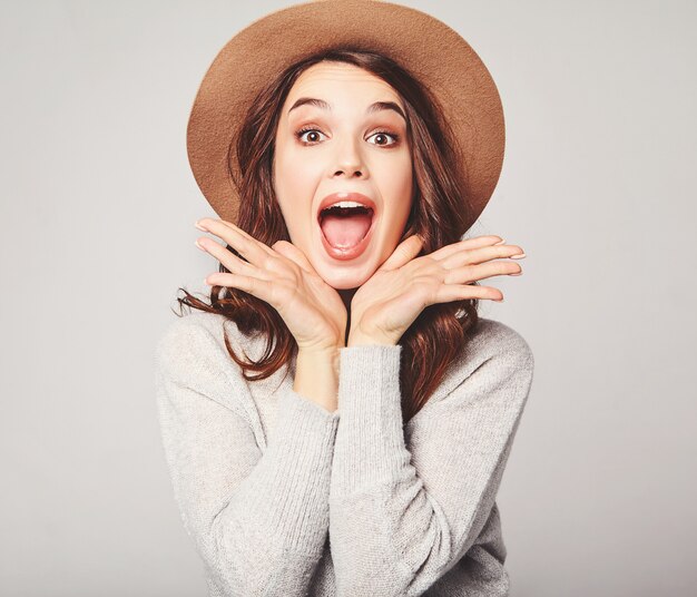 Portrait of young stylish  model excited screaming shocked in gray casual summer clothes in brown hat