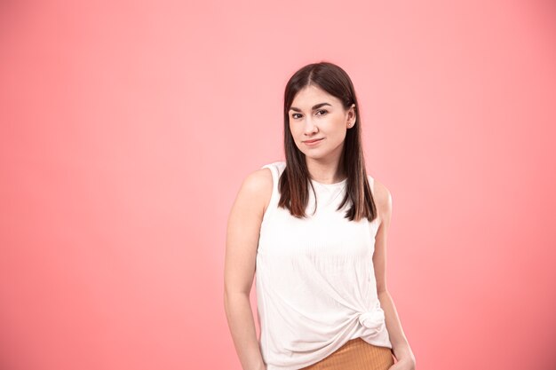 Portrait of young stylish woman on pink background isolated copy space.