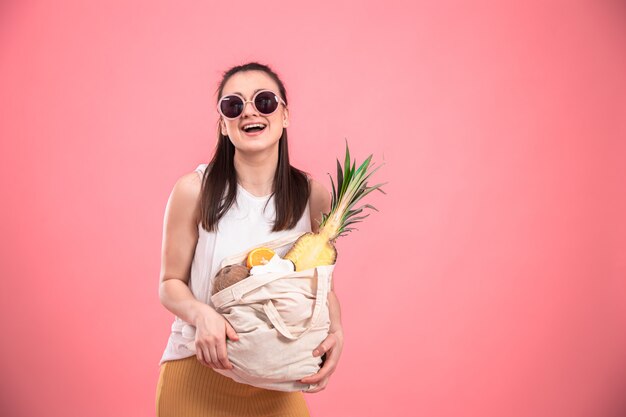 Портрет молодой стильной женщины с эко-фруктовой сумкой