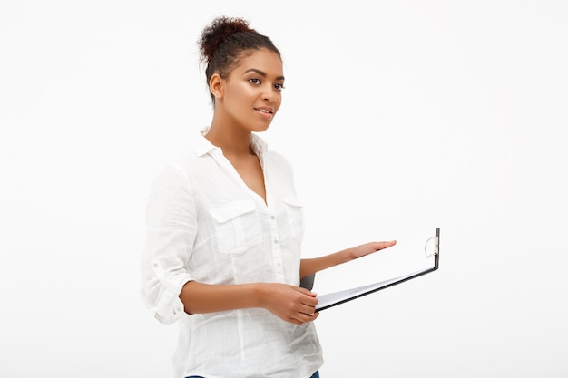 Portrait of young successful african business lady over white wall