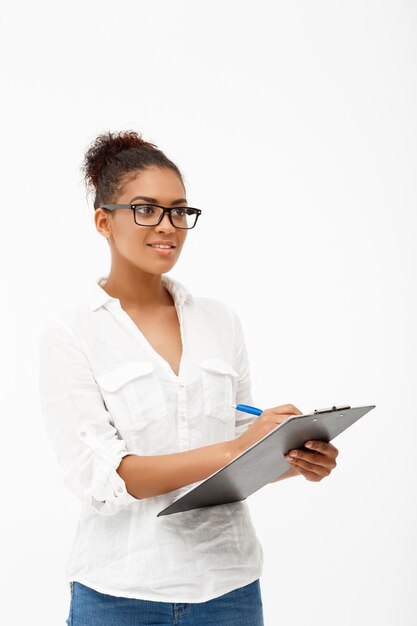 Portrait of young successful african business lady over white wall