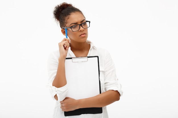 Portrait of young successful african business lady over white wall