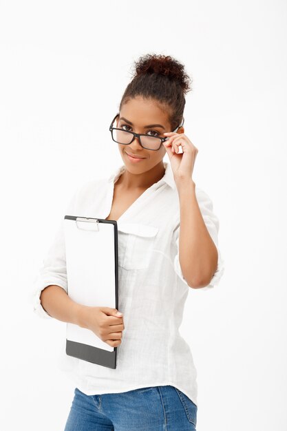 Portrait of young successful african business lady over white wall