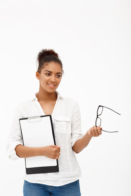 Portrait of young successful african business lady over white wall