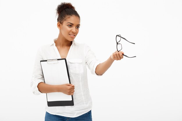 Portrait of young successful african business lady over white wall