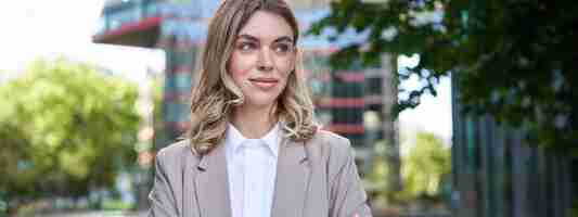 Free photo portrait of young successful businesswoman in suit cross arms on chest smile and look confident