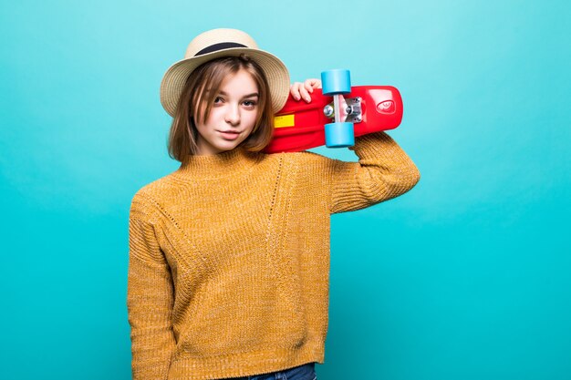 Портрет молодой женщины в солнцезащитные очки и шляпу, держа скейтборд