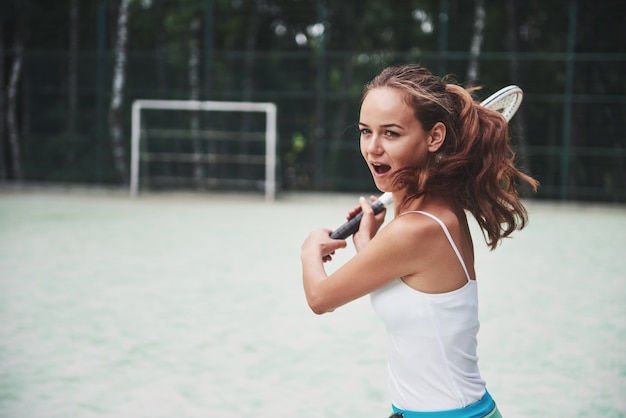 Free photo portrait of a young tennis player standing ready for a serve.