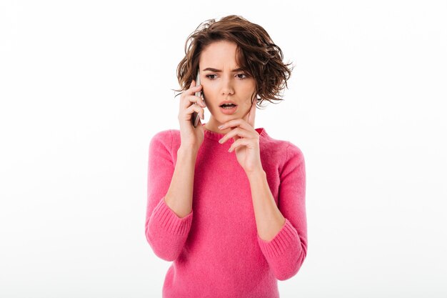 Portrait of a young thoughtful girl holding mobile phone