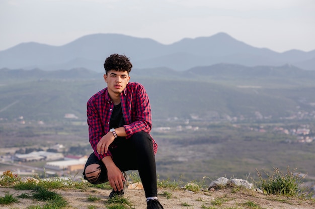 Portrait of young traveler man posing on hill