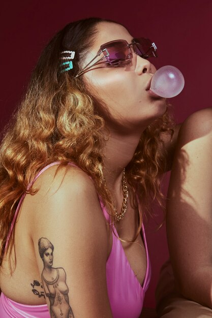 Portrait of young woman in 2000s fashion style posing with bubblegum