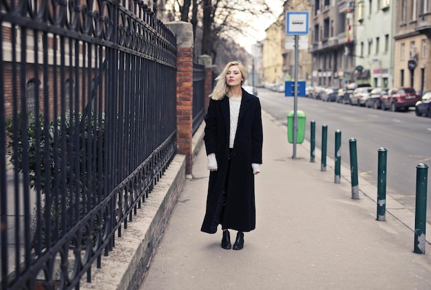 Free photo portrait of young woman in a black coat in the street