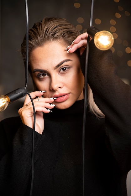 Portrait of young woman in black sweater standing and posing