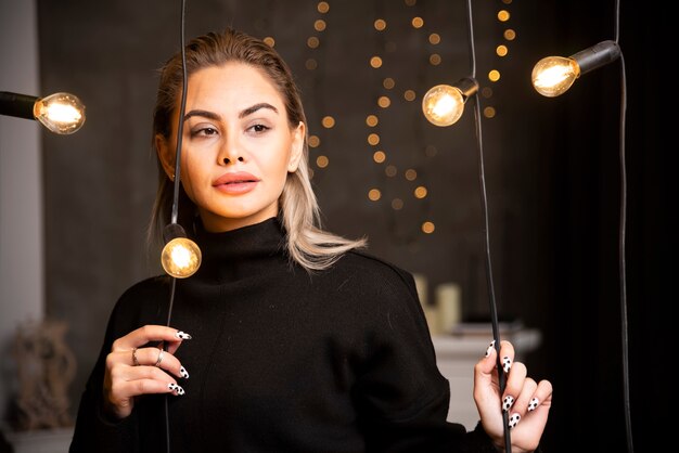 Portrait of young woman in black sweater standing and posing.