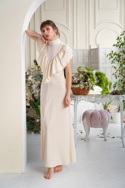 Ritratto di giovane donna in abito boho con romantica estetica da giardino e vegetazione