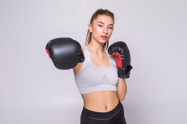 Free photo portrait of a young woman boxer throwing a punch at front while practicing