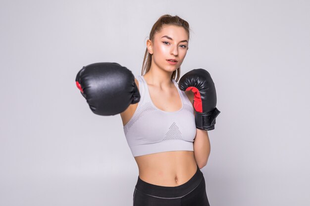 Portrait of a young woman boxer throwing a punch at front while practicing