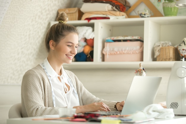 Free photo portrait of a young woman cloth designer with laptop