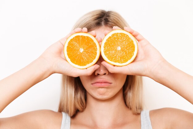 オレンジ色の果物で彼女の目を覆っている若い女性の肖像画