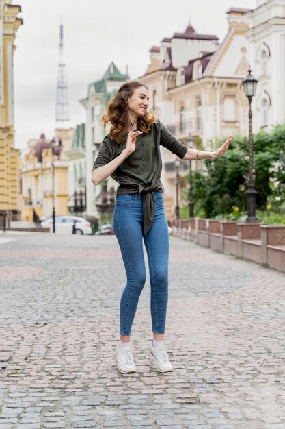 Portrait young woman dancing on street