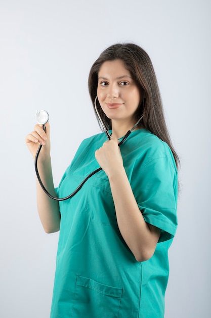 Портрет молодой женщины-врача со стетоскопом в униформе.