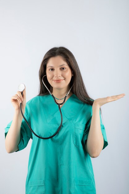 제복을 입은 청진기를 가진 젊은 여성 의사의 초상화.