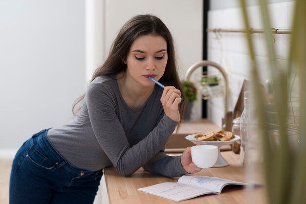 コーヒーを飲みながら宿題をしている若い女性の肖像画