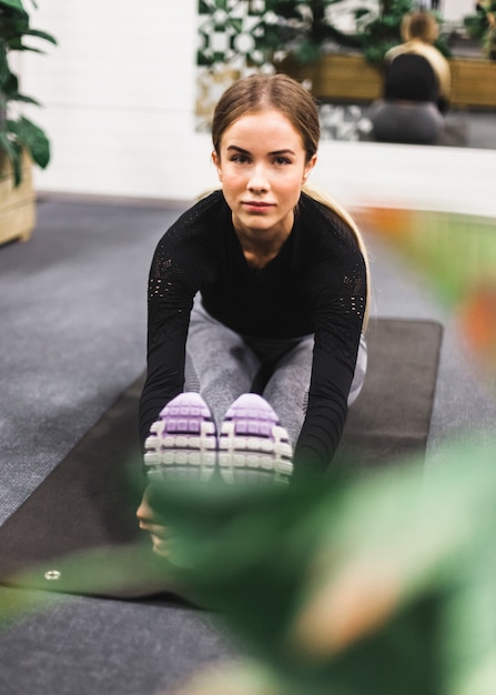 Foto gratuita ritratto di una giovane donna che fa esercizio di stretching