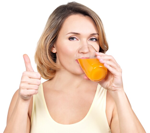 若い女性の肖像画は、白で隔離のオレンジジュースを飲みます。