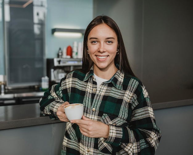 Foto gratuita ritratto di una giovane donna che gode del caffè