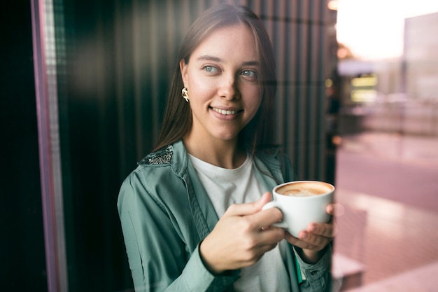 Портрет молодой женщины, наслаждающейся кофе