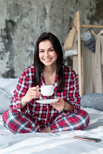 Portrait of young woman enjoying morning in bed
