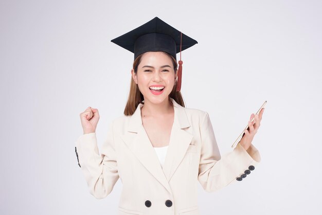 Portrait of young woman graduated over white background
