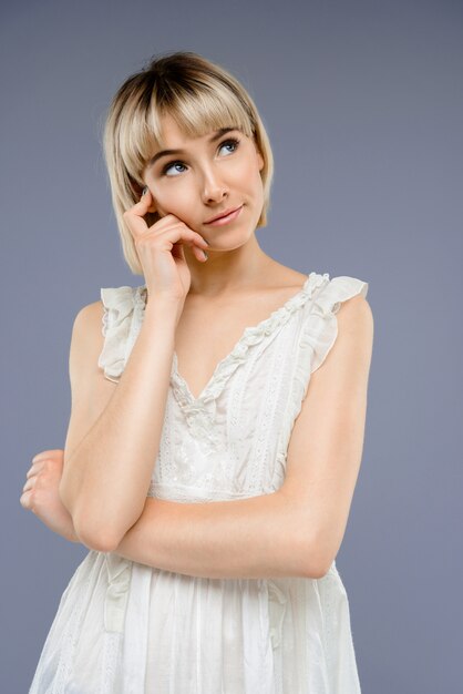 Portrait of young woman over grey wall