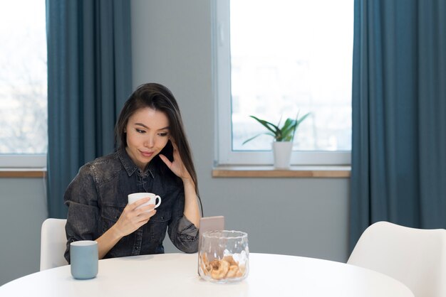 Portrait of young woman having coffee at home