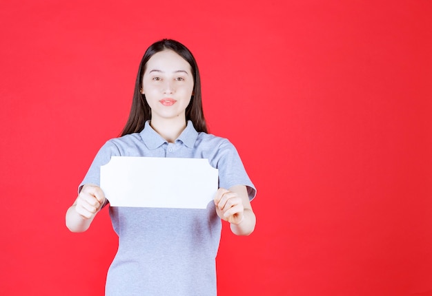 Portrait of young woman holding board