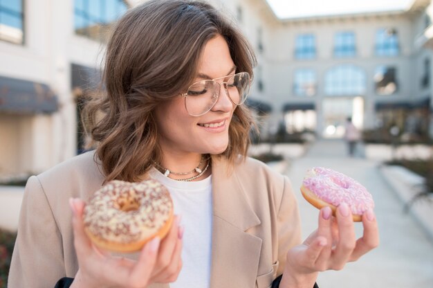 Portrait of young woman holding doughnuts